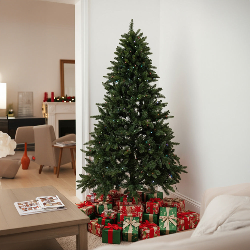 Garden Sanctuary 4ft artificial Christmas tree with RGB lights and wood stand, decorated with green pine branches and colorful ornaments.