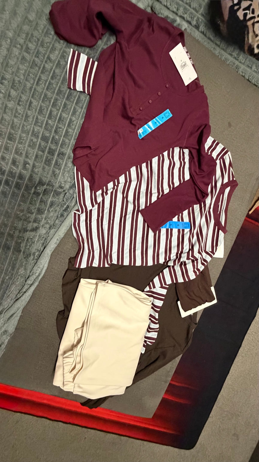 Burgundy striped and neutral clothing bundle flat lay